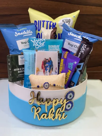 For Rakhi, I create hampers that are full of personality. This one for a brother is packed with his favorite healthy snacks, protein bars, and a personalized photo frame to make the gift truly special.