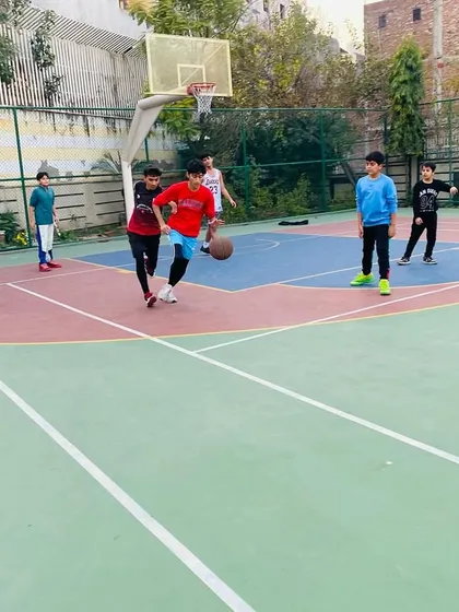 A young player learns to handle the ball against pressure from a defender.