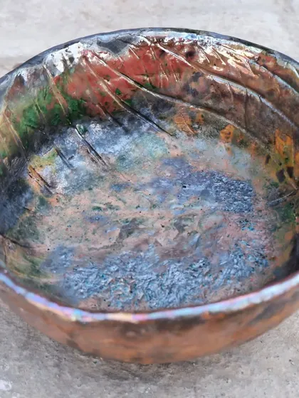 The inside of this Raku bowl is a universe of color and texture. The metallic and matte finishes are a result of the intense reduction atmosphere during firing.