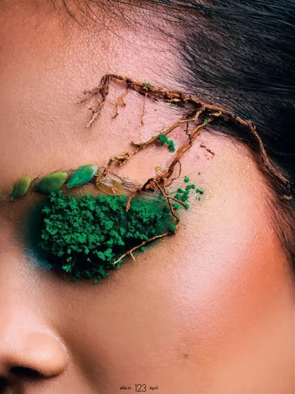 An extreme close-up on the eye makeup from the 'Becoming Earth' shoot. This macro shot reveals the texture of the green powder and the delicate placement of root-like elements.