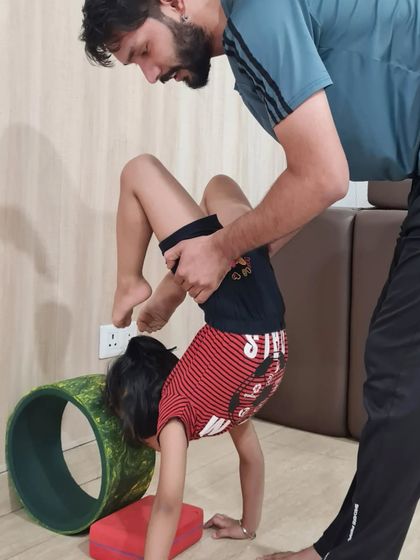 Each child receives individual attention to ensure they are practicing safely. Here, I am helping a young student with her form in an inversion, building her confidence to try new things.