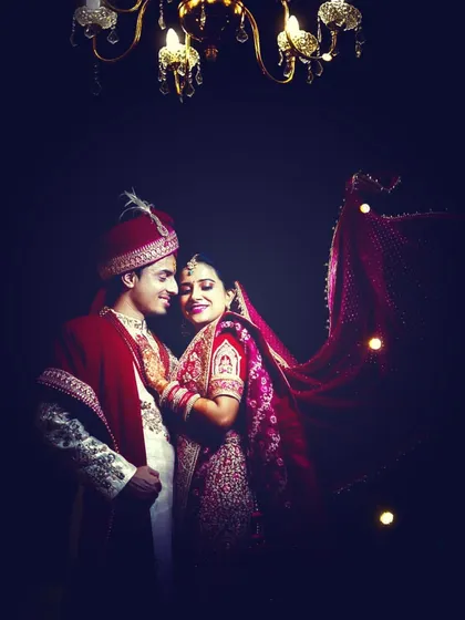 A royal-looking indoor wedding portrait, using dramatic lighting to create a rich and elegant photograph.