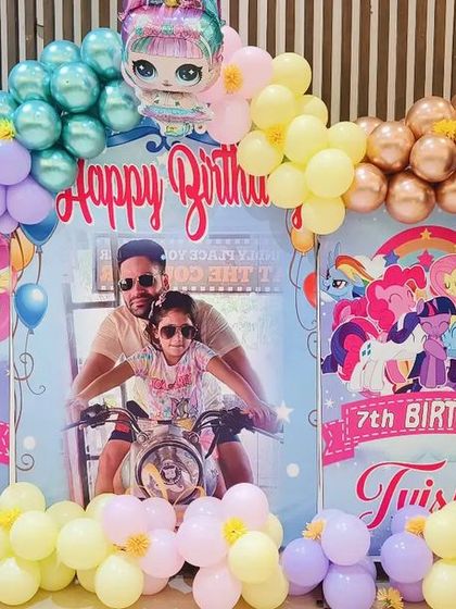 A closer look at the custom backdrop for the butterfly and pony themed party. The combination of the personal photo with the cartoon characters makes it a unique and cherished decoration.