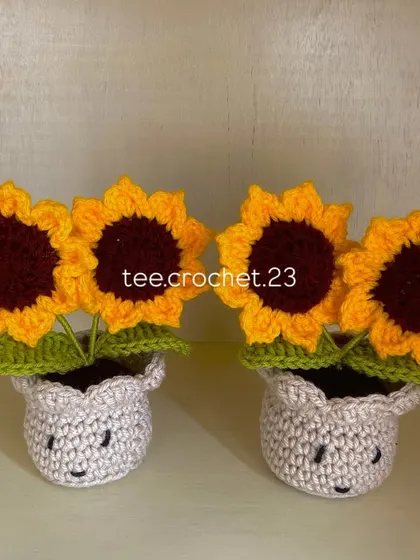 A pair of my signature potted sunflowers, each with a little smiley face stitched onto the crocheted pot.