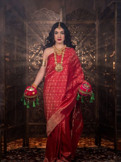 A full-length shot showing the rich red saree and traditional props. This was a special project to celebrate the festival through art.