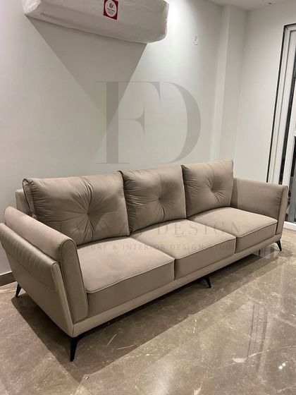 This three-seater sofa in a neutral beige features deep, tufted back cushions for added comfort. Its clean lines and simple form make it a versatile foundation for any living room design.