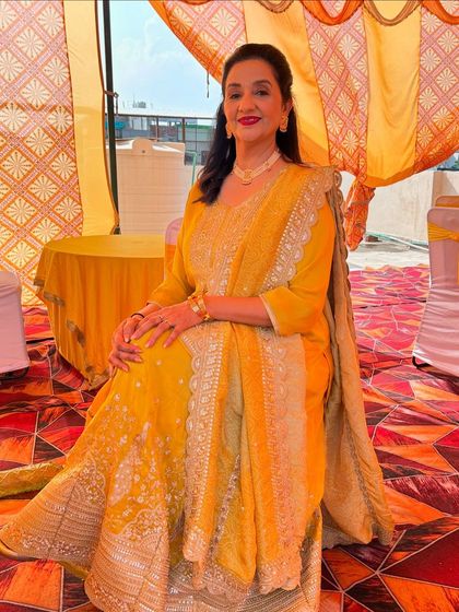 A full-length seated shot, showing the beautiful details of her outfit.