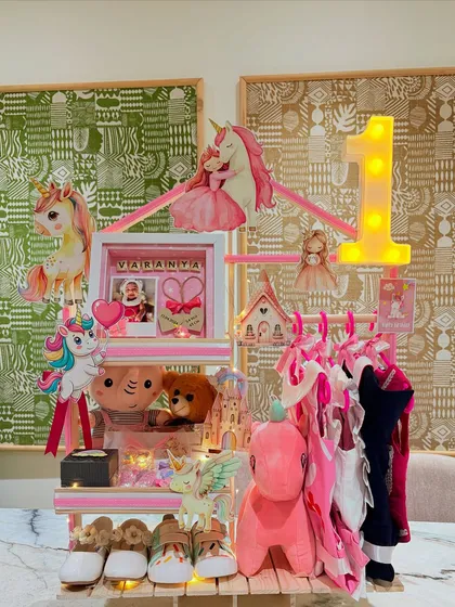The complete Unicorn Wonderland hamper, a multi-tiered gift structure filled with clothes, toys, and keepsakes to celebrate a magical first birthday.