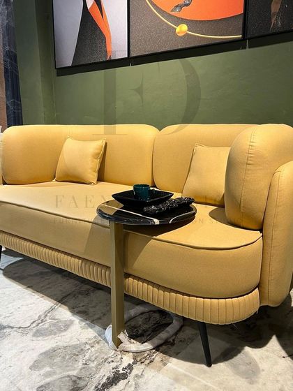 A full view of a living room featuring our vibrant yellow sofa. Paired with modern art and marble-topped side tables, it demonstrates how a single colorful piece can define and energize an entire space.