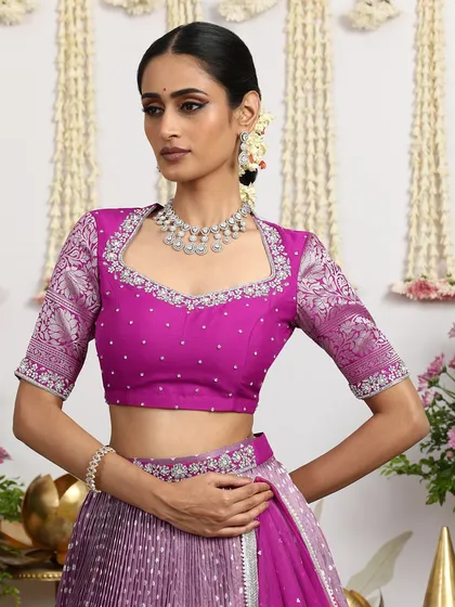 A close-up of the magenta blouse, featuring a unique neckline and intricate embroidery.