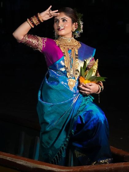 Celebrating the festival of Narali Purnima with a traditional look. The bride stands in a boat, her makeup flawless, ready to offer prayers to the sea god.