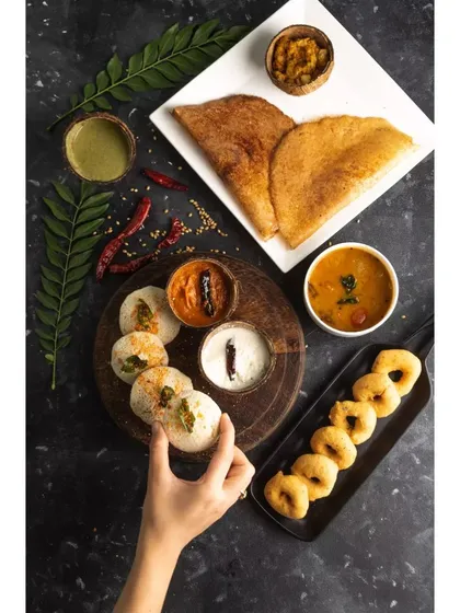 A complete South Indian breakfast spread, styled and shot for Double Tree by Hilton. This top-down flatlay captures the variety of the meal, from crispy dosas to savory sambar, perfect for a hotel menu.
