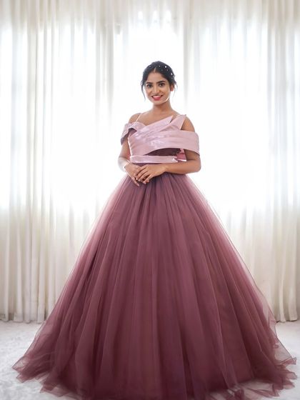 Introducing 'Royalty', an elegant ball gown with a unique off-shoulder pleated bodice and a full tulle skirt in a beautiful dusty rose color.