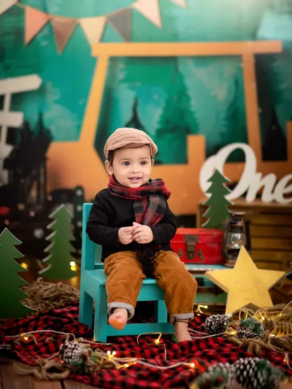 Our little camper, looking cozy and cute in his scarf and cap. The rustic, woodland theme is perfect for an adventurous first birthday shoot.