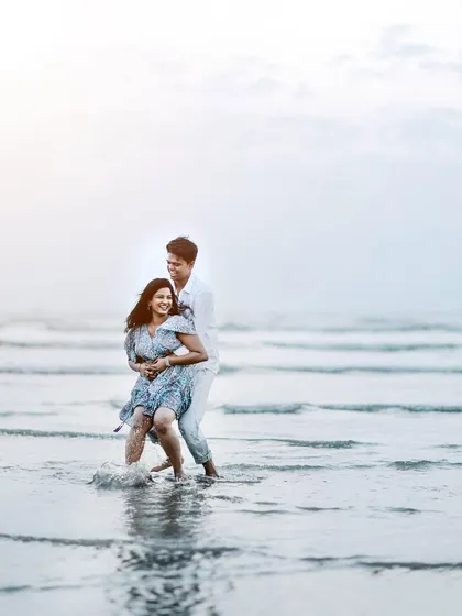 A fun splash in the water. This candid shot shows the playful side of a couple's relationship during their beach pre-wedding session.