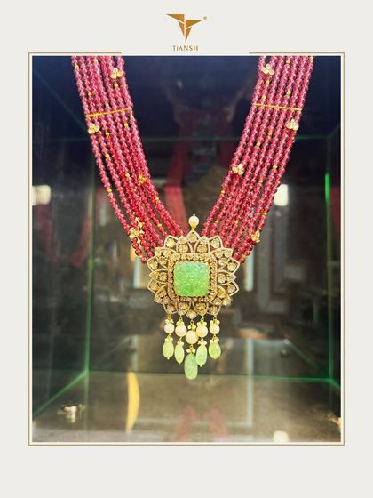 A stunning fusion of deep red ruby strands and a carved jade centerpiece, framed in gold and Polki. This necklace speaks the language of regal tradition and is perfect for a bride who loves bold hues and timeless artistry.
