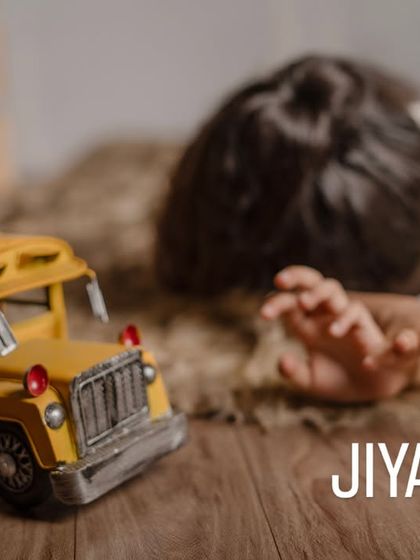 An artistic and playful shot focusing on a toy school bus, with the child resting in the background. This shows our creative approach to capturing the world from a child's perspective.