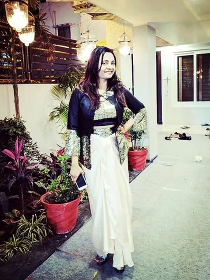 One of my happy clients looking radiant in a custom Indo-western outfit. This ensemble pairs a draped dhoti-style skirt with a sequined crop top and a structured jacket, perfect for a wedding reception or cocktail event.