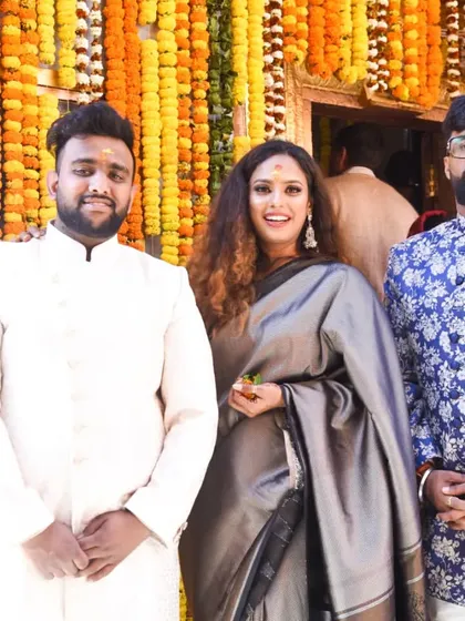 Attending my sister's wedding with my brothers. I opted for a sophisticated grey saree, which stands out beautifully against the vibrant marigold decor. This is a great Indian wedding guest style inspiration.