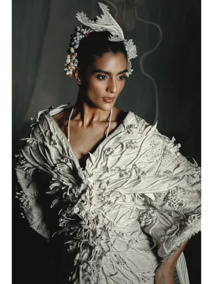 Another angle of the textured white jacket from the Vaishali S. campaign. The styling with the delicate floral headpiece adds a touch of softness to the powerful, structured garment.
