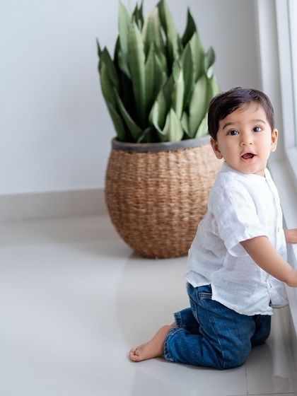 A curious toddler exploring the studio by the window.
