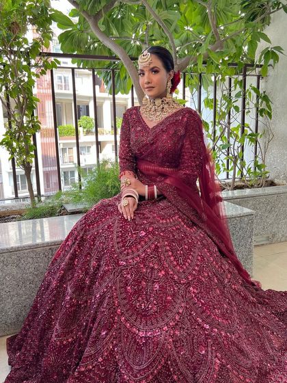 A full-length shot of this stunning bride. The monochromatic wine-colored outfit is paired with makeup that is both bold and elegant.