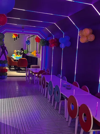 The cool, neon-lit dining area for a kids' party. We work with the venue to ensure our catering setup complements the ambiance perfectly.
