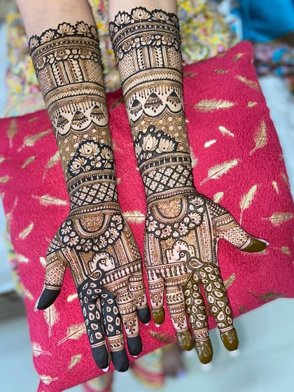 A gorgeous design featuring peacocks on the palms and intricate floral and jaali patterns extending up the arms.