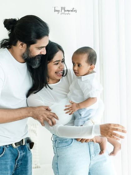 Gazing at their beautiful baby. This natural light portrait by the window creates a soft, intimate, and timeless family photo.