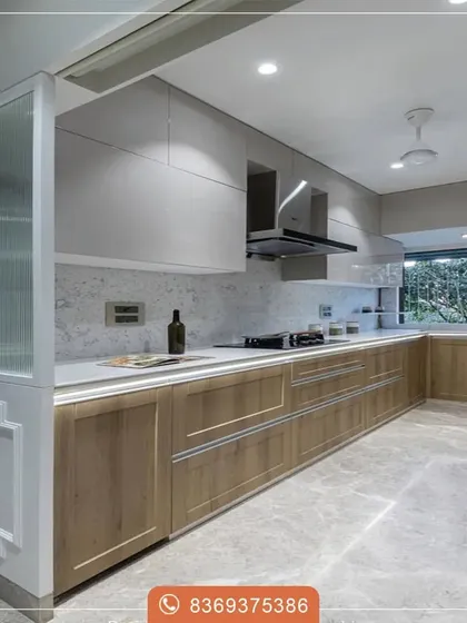 This long kitchen layout uses a mix of materials to create a sophisticated look. The light wood grain of the lower cabinets contrasts beautifully with the sleek white uppers and the textured marble-style backsplash.