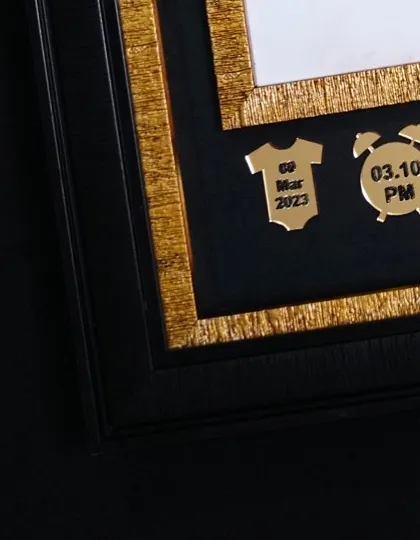 It is all in the details. These small, golden charms record the baby's birth date and time, adding a very personal and informative element right into the artwork.