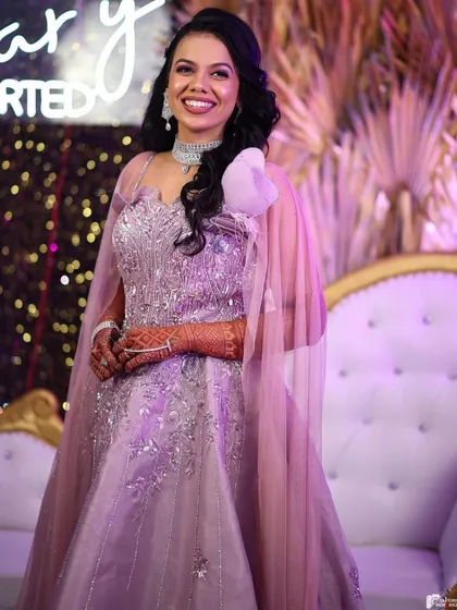 The best part of our job is seeing our happy clients. This beautiful client is glowing in one of our lavender reception gowns, complete with delicate embroidery and a stylish shoulder cape. Her smile says it all.