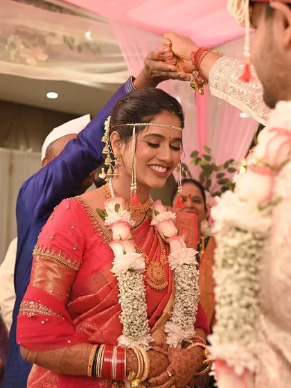 The bride's happy smile as the wedding rituals proceed. Her natural and radiant look is perfect for these unforgettable moments.