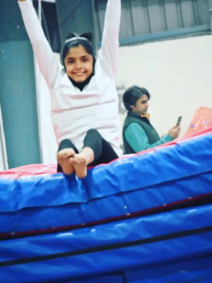 A happy gymnast enjoying a moment of rest on the mats. We balance hard work with fun.