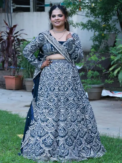A full-length view of the navy blue lehenga, showcasing the complete outfit. Renting allows you to feature multiple high-value looks like this without the investment of purchasing them.