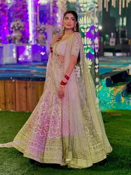 A full-length shot of my look for a wedding event. An elegant white and gold lehenga.