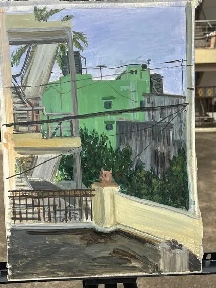 A close-up of the finished rooftop painting, highlighting the details of the architecture and the little cat on the wall.