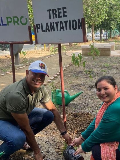 Employees from Calpro Specialities and their children plant saplings together at Aravali Creek, inspiring the next generation to care for the environment.