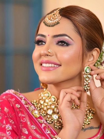 A complete bridal look featuring a heavy, gold-plated Kundan necklace, haath phool, and maang tikka, all available for rent.