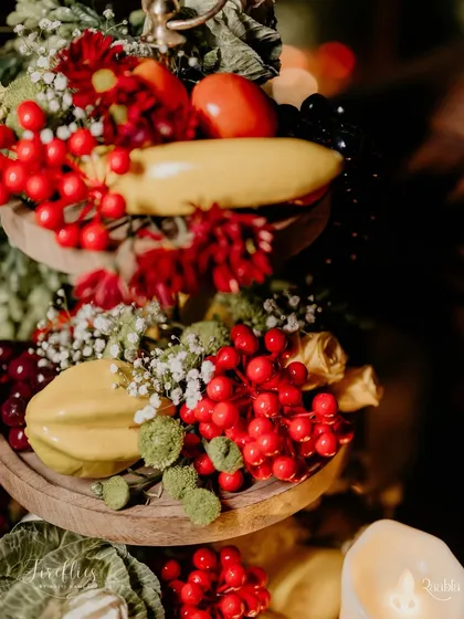 A centerpiece for the Italian dinner, featuring fresh fruits and vegetables like tomatoes and berries, adding a rustic and authentic touch.