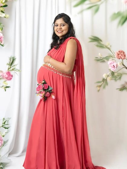 A standing portrait framed by beautiful flowers. The addition of a small bouquet on the baby bump is a lovely detail that celebrates new life.