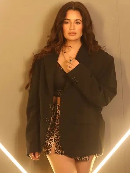 A full-body shot that shows how the hair and makeup work with the entire outfit, including the bold animal print and statement boots.