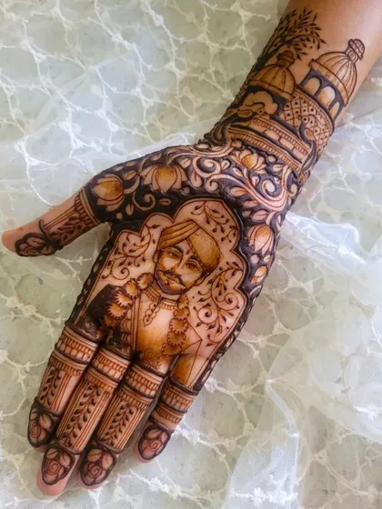 A closer look at the groom's portrait from a personalized bridal design. Above the portrait, you can see a depiction of a Gurudwara, a place of great significance for the couple.