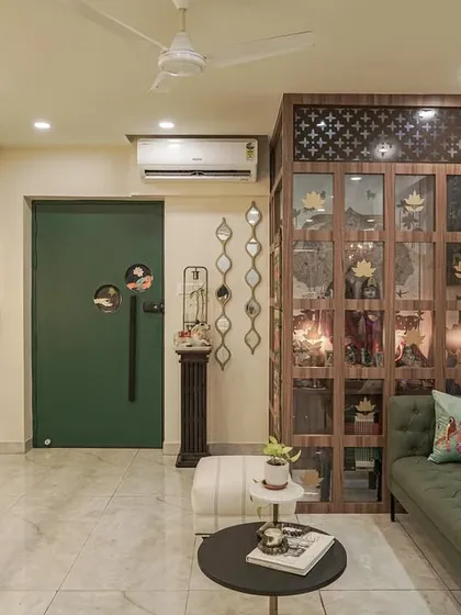 A view of the living room from image 22, focusing on the green sofa and hand-painted partition.