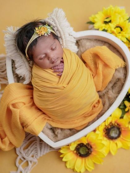 A heart of gold. The yellow swaddle and matching sunflowers create a bright and joyful portrait that is full of warmth.