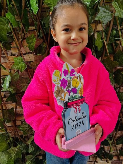 This student in her bright pink jacket is delighted with the 2025 calendar she created.
