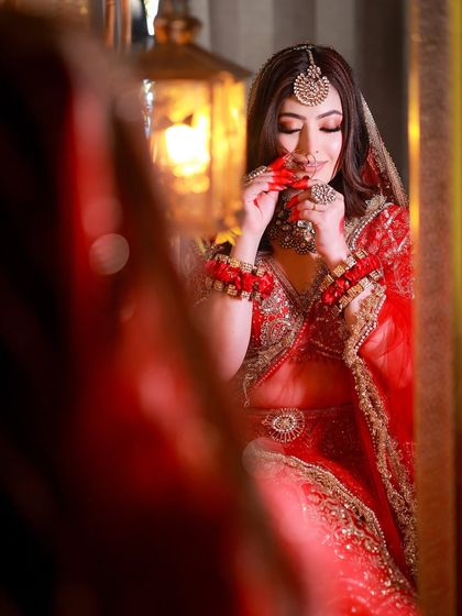 Another creative reflection shot, capturing a candid moment of the bride adjusting her nath.
