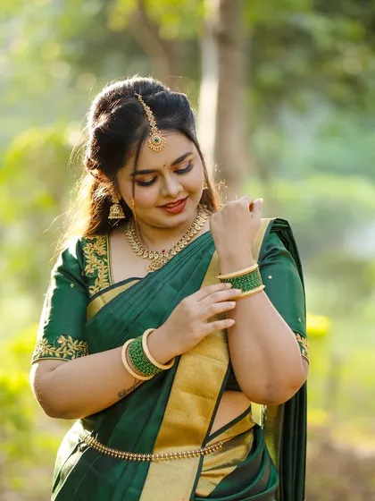 The bride adjusting her bangles, a classic pose that shows off her henna and jewellery.