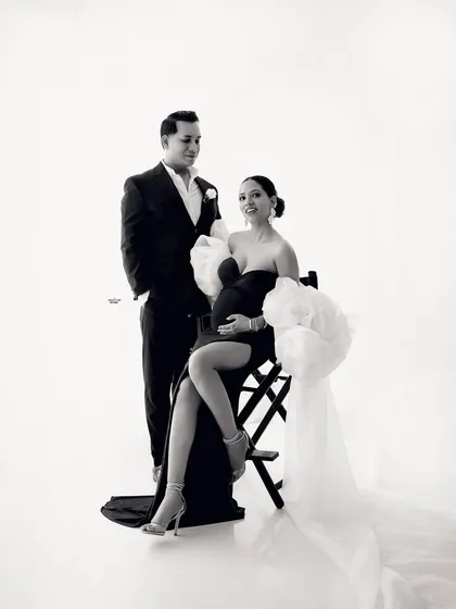 A classic, glamorous pose. The mamma-to-be looks stunning in her gown, seated on a director's chair, with her dapper partner by her side.