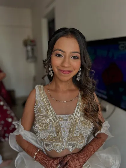 A fresh and pretty look for a daytime event. The client is wearing a white and gold lehenga, and her makeup is light and radiant.